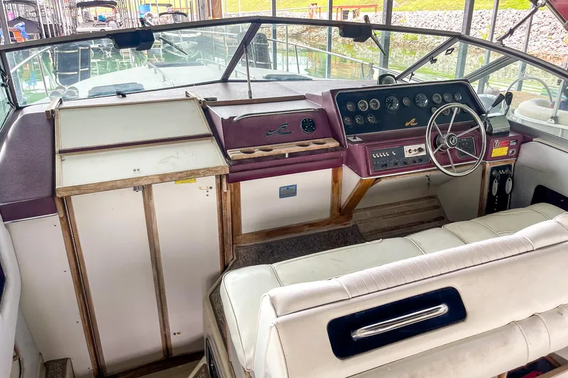 Slide: The Image of 1987 Sea Ray 300 Sundancer boat interior with steering wheel and dashboard controls. - 16
