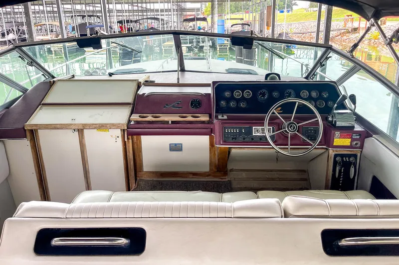 Slide: The Image of 1987 Sea Ray 300 Sundancer boat cockpit with steering wheel and control panel. - 17