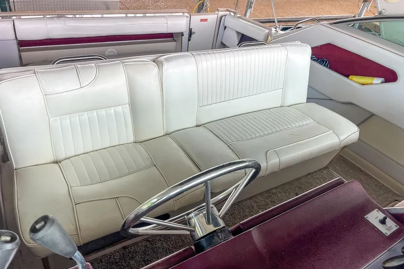 Slide: The Image of 1987 Sea Ray 300 Sundancer interior with white seating and steering wheel. - 19