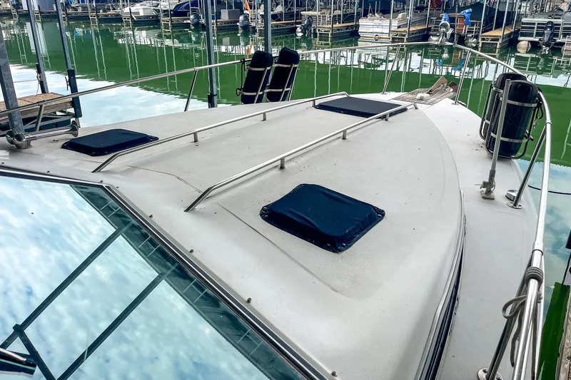 Slide: The Image of 1987 Sea Ray 300 Sundancer boat docked at marina, showing deck and railings. - 20