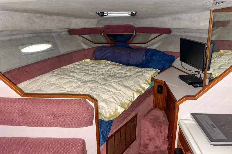 Slide: The Image of Cozy cabin interior of 1987 Sea Ray 300 Sundancer with bed and TV. - 24