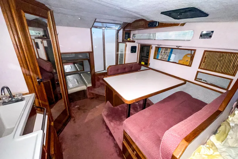 Slide: The Image of Interior of 1987 Sea Ray 300 Sundancer with dining area and wooden cabinetry. - 25
