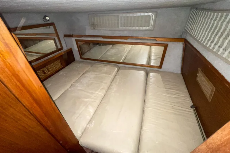 Slide: The Image of 1987 Sea Ray 300 Sundancer cabin interior with beige cushions and wooden accents. - 30