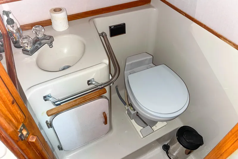 Slide: The Image of 1987 Sea Ray 300 Sundancer bathroom with sink, toilet, and wooden accents. - 31