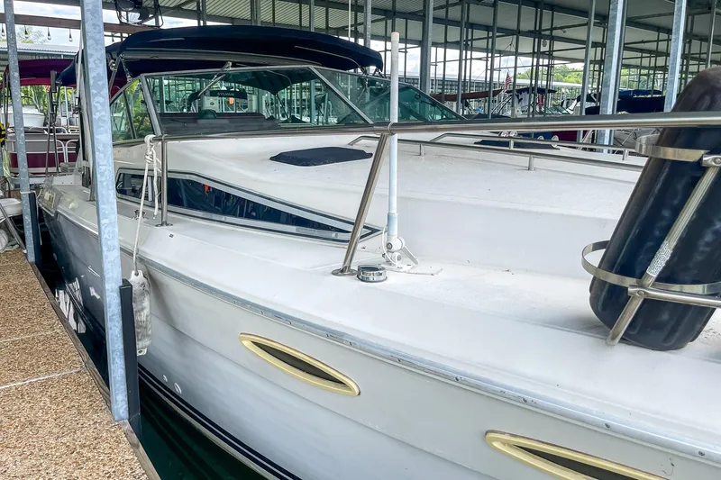 Slide: The Image of 1987 Sea Ray 300 Sundancer docked in a marina, showcasing sleek design and spacious deck. - 5