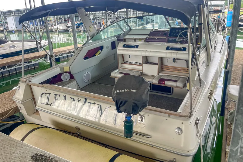 Slide: The Image of 1987 Sea Ray 300 Sundancer boat docked, featuring spacious seating and covered helm area. - 8