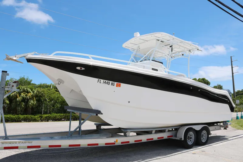 The Image of 2006 ProKat 2360 Center Console boat on trailer, parked outdoors under blue sky. - 0