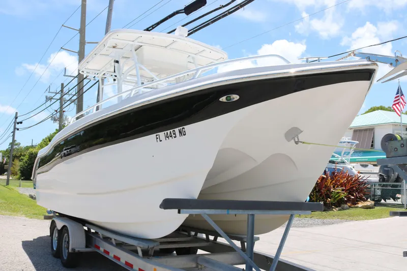 Slide: The Image of 2006 ProKat 2360 Center Console boat on trailer, parked outdoors under blue sky. - 2