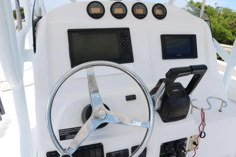 Slide: The Image of 2006 ProKat 2360 Center Console boat dashboard with steering wheel and controls. - 5