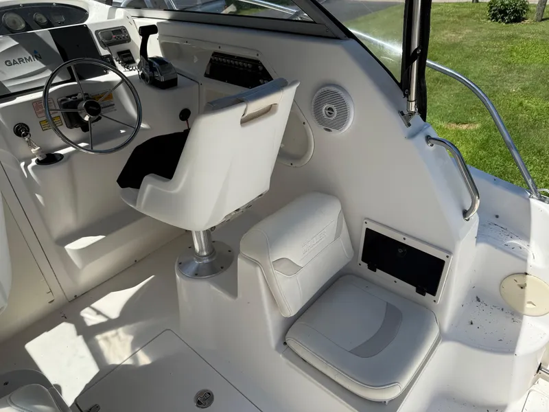 Slide: The Image of 2002 Boston Whaler 255 Conquest boat interior with steering wheel and seating. - 12