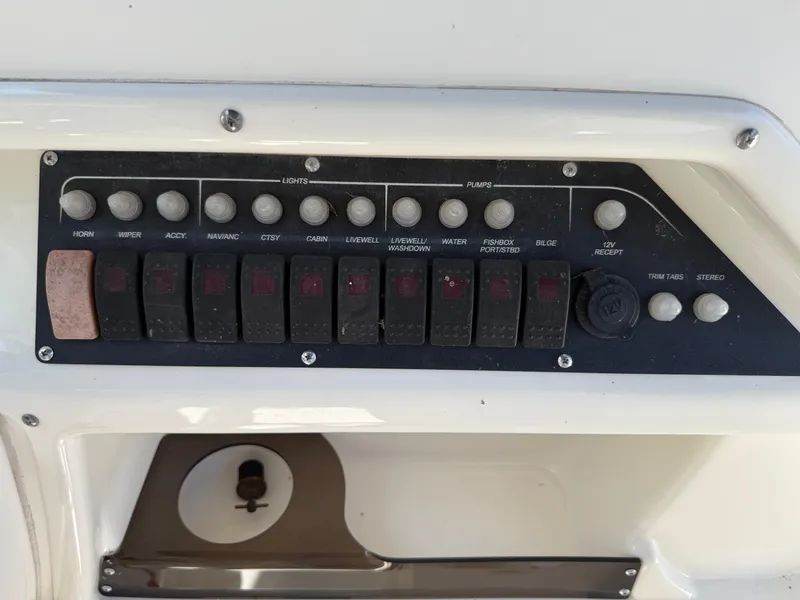 Slide: The Image of Control panel of a 2002 Boston Whaler 255 Conquest boat with labeled switches and buttons. - 14