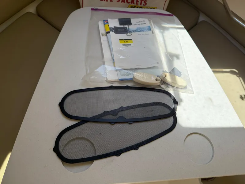 Slide: The Image of 2002 Boston Whaler 255 Conquest boat accessories and manuals on table. - 23