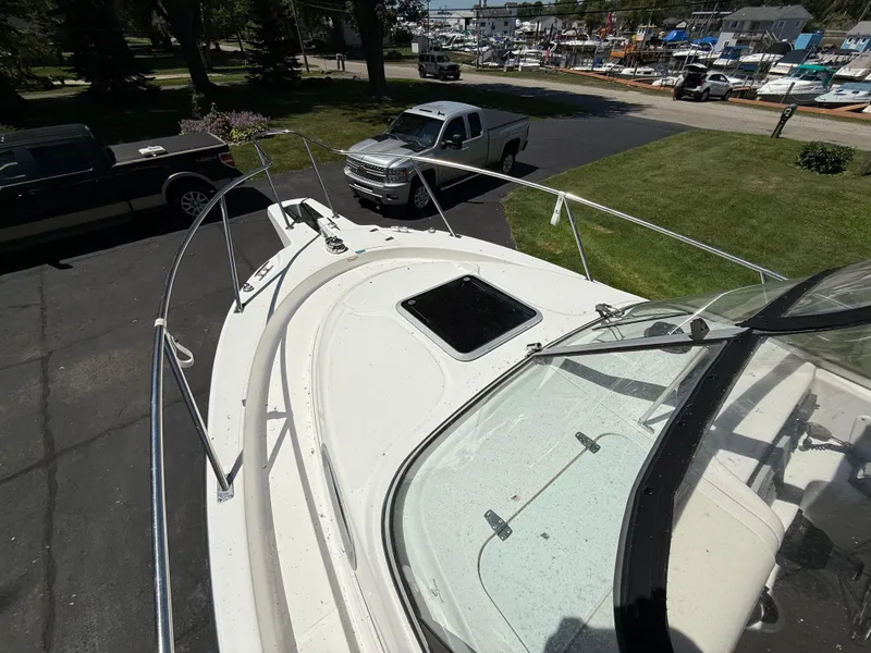 Slide: The Image of 2002 Boston Whaler 255 Conquest boat on trailer, parked near trucks and marina. - 26