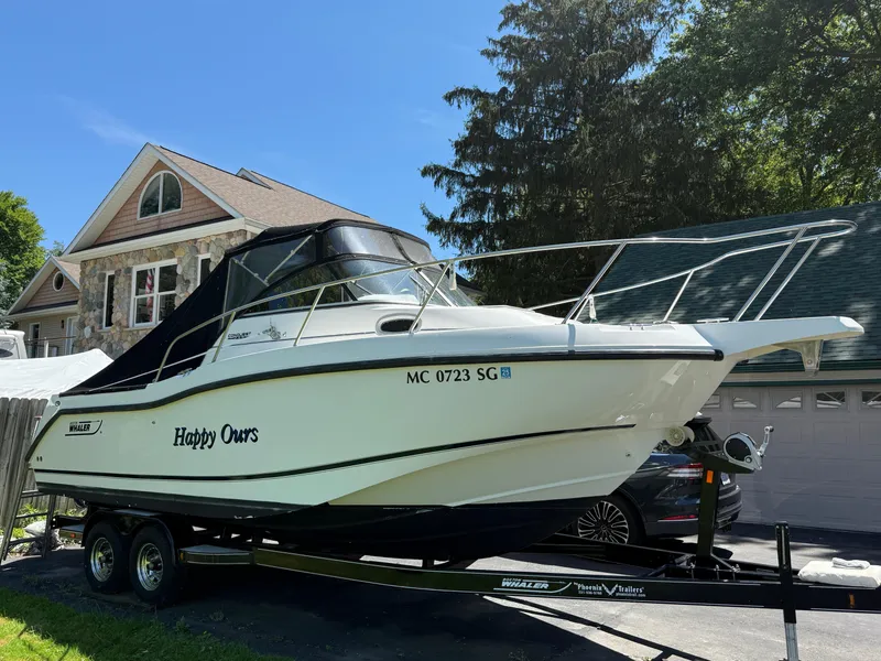 Slide: The Image of 2002 Boston Whaler 255 Conquest boat on trailer, parked near a house. - 39