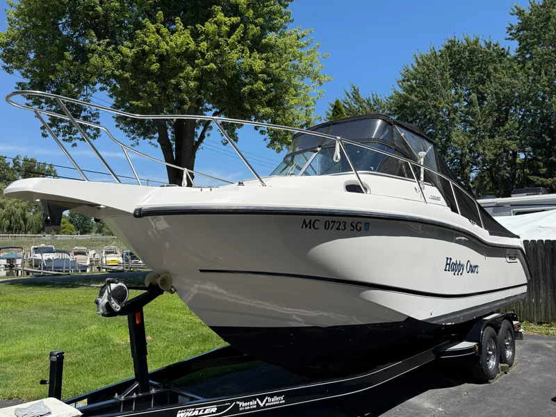 Slide: The Image of 2002 Boston Whaler 255 Conquest boat on trailer, parked outdoors on a sunny day. - 42