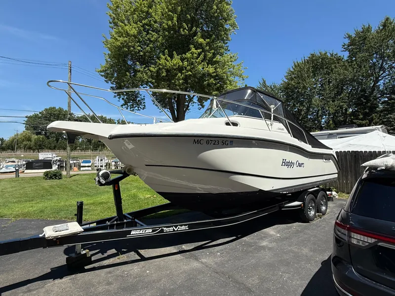 Slide: The Image of 2002 Boston Whaler 255 Conquest boat on trailer, parked outdoors on a sunny day. - 43