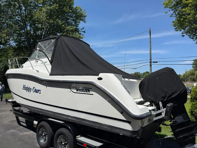 Slide: The Image of 2002 Boston Whaler 255 Conquest boat on trailer, covered, outdoors. - 45