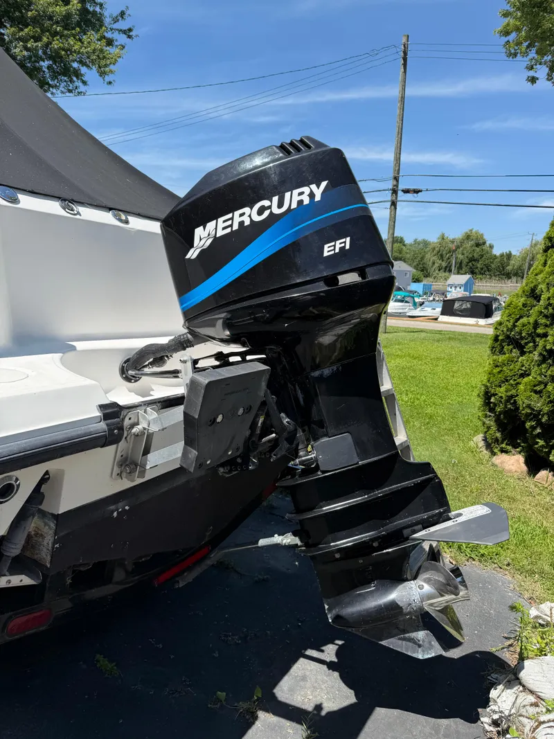 Slide: The Image of 2002 Boston Whaler 255 Conquest with Mercury EFI outboard motor in a sunny outdoor setting. - 46