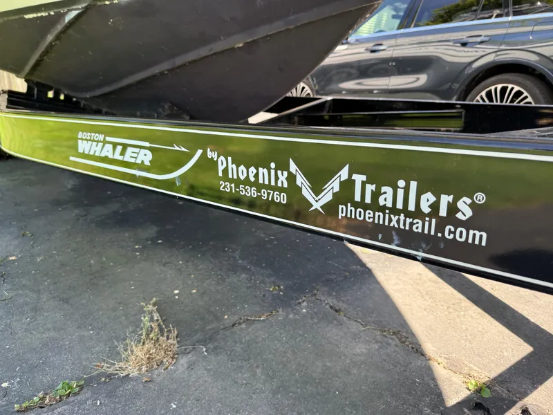 Slide: The Image of Trailer for 2002 Boston Whaler 255 Conquest by Phoenix Trailers, parked on pavement. - 48