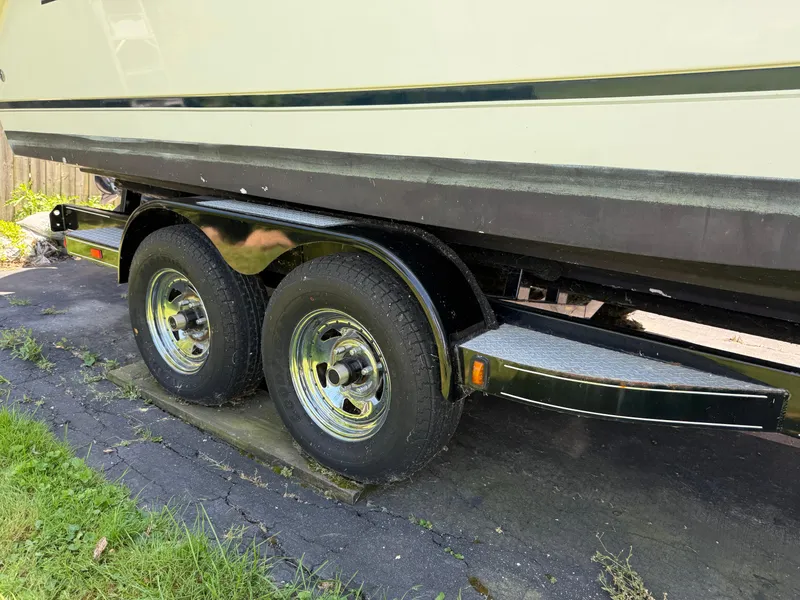 Slide: The Image of Trailer for 2002 Boston Whaler 255 Conquest boat, featuring dual wheels on pavement. - 49