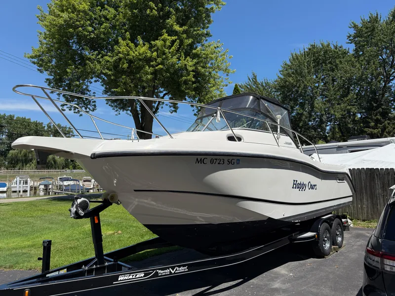 Slide: The Image of 2002 Boston Whaler 255 Conquest boat on trailer, parked outdoors, sunny day. - 5