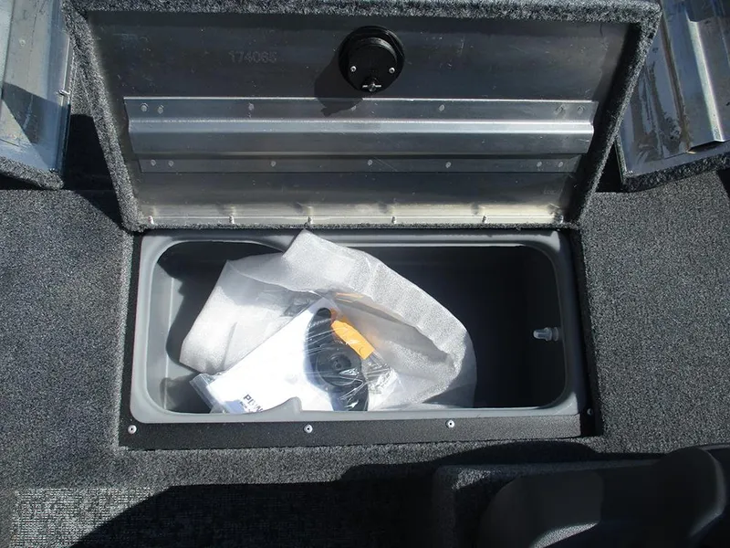 Slide: The Image of Storage compartment in 2026 Tracker Super Guide V-16 SC boat, containing wrapped items. - 18