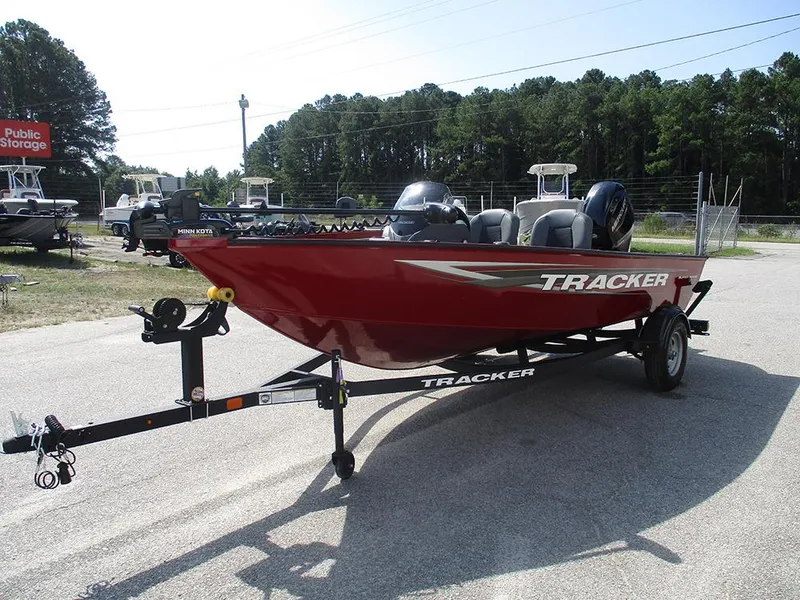 Slide: The Image of 2026 Tracker Super Guide V-16 SC boat on trailer, red exterior, parked outdoors. - 2