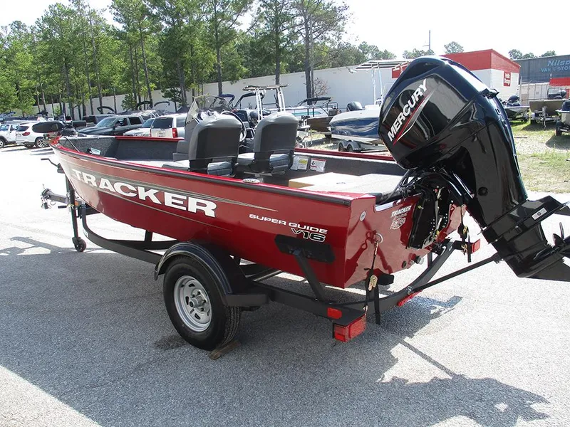 Slide: The Image of 2026 Tracker Super Guide V-16 SC boat with Mercury engine in a parking lot. - 3