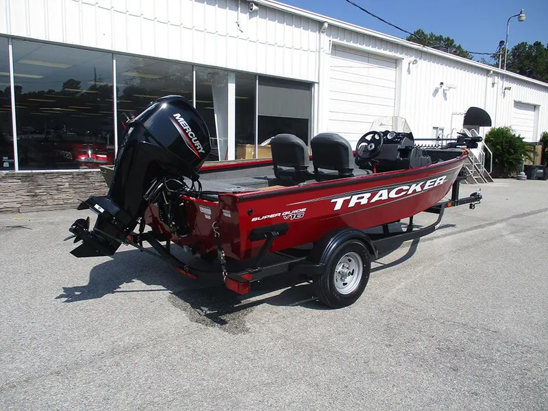 Slide: The Image of 2026 Tracker Super Guide V-16 SC boat with Mercury engine, parked outside a building. - 6