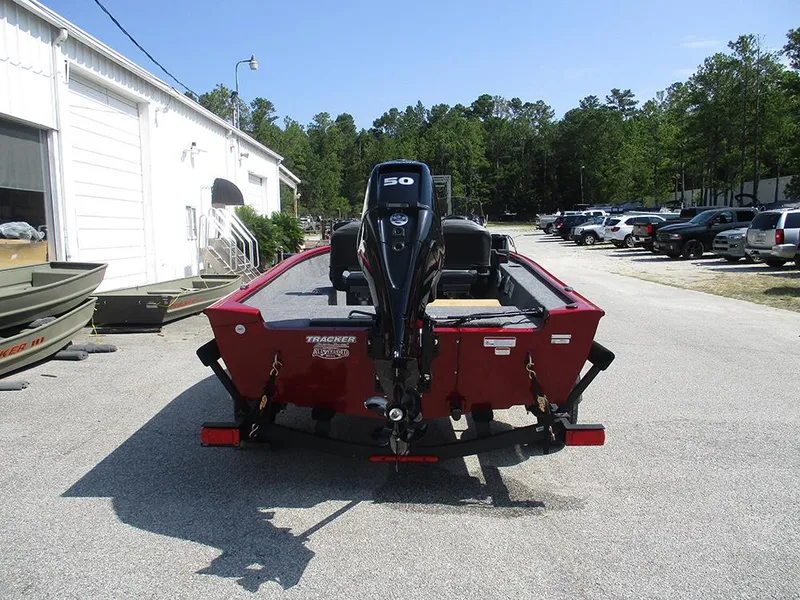 Slide: The Image of 2026 Tracker Super Guide V-16 SC boat with outboard motor, parked outdoors. - 7