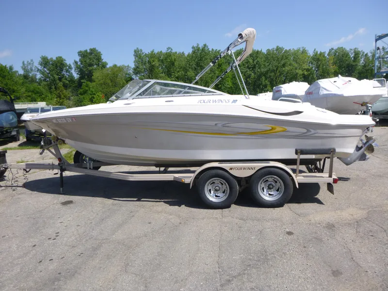 Slide: The Image of 2006 Four Winns 220 Horizon boat on trailer, parked outdoors on a sunny day. - 4