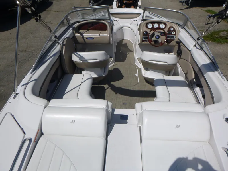 Slide: The Image of 2006 Four Winns 220 Horizon boat interior with white seating and steering console. - 5