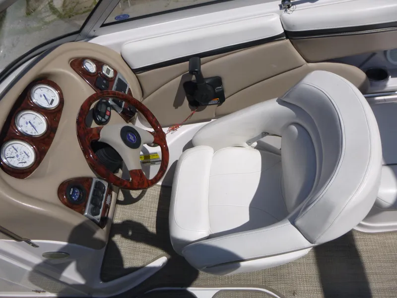 Slide: The Image of 2006 Four Winns 220 Horizon boat cockpit with white seating and wood-accented dashboard. - 7