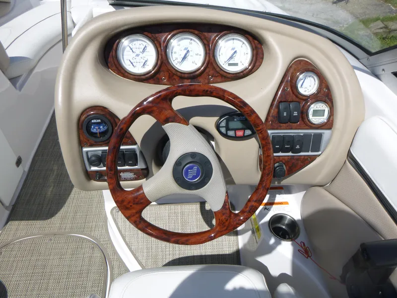 Slide: The Image of 2006 Four Winns 220 Horizon boat dashboard with wood accents and gauges. - 8