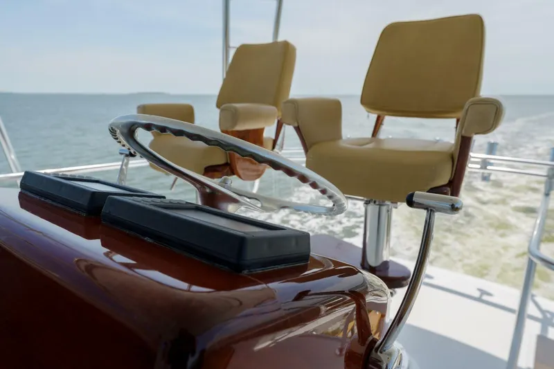 Slide: The Image of Helm of 2000 Garlington 61 C yacht with dual captain chairs, steering wheel, and ocean view. - 16