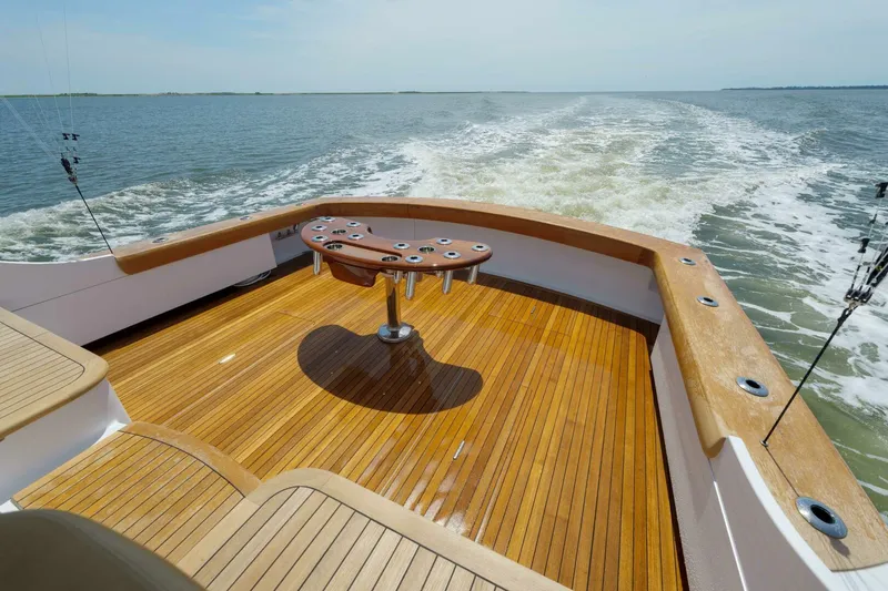 Slide: The Image of Sleek Garlington 61 C yacht deck with fishing rod holders, cruising on open water. - 17