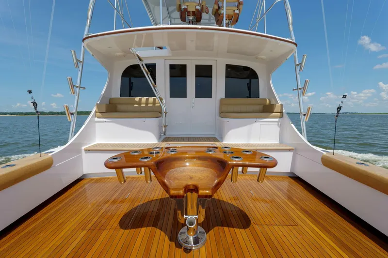 Slide: The Image of Luxury Garlington 61 C yacht deck with wooden flooring, fishing rod holders, and cushioned seating, 2000 model. - 20