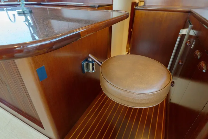 Slide: The Image of Luxurious wooden interior of a 2000 Garlington 61 C yacht with a leather stool. - 34