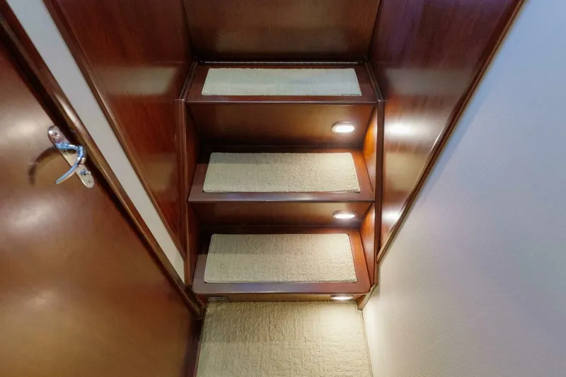 Slide: The Image of Wooden staircase with carpeted steps and lighting in a 2000 Garlington 61 C yacht. - 46