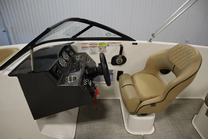 Slide: The Image of 2024 Bayliner VR5 Bowrider cockpit with beige captain's seat and control panel. - 12