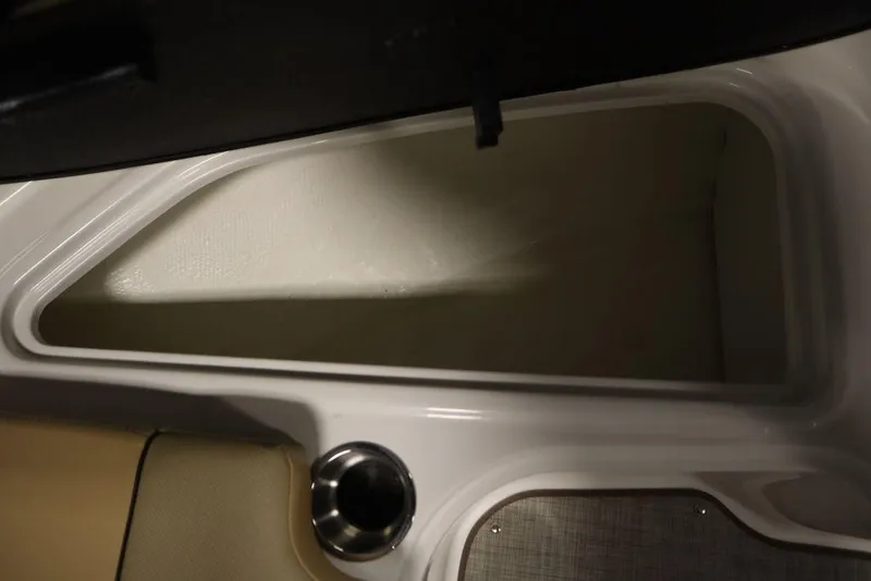 Slide: The Image of 2024 Bayliner VR5 Bowrider storage compartment with cup holder, showcasing interior design. - 14