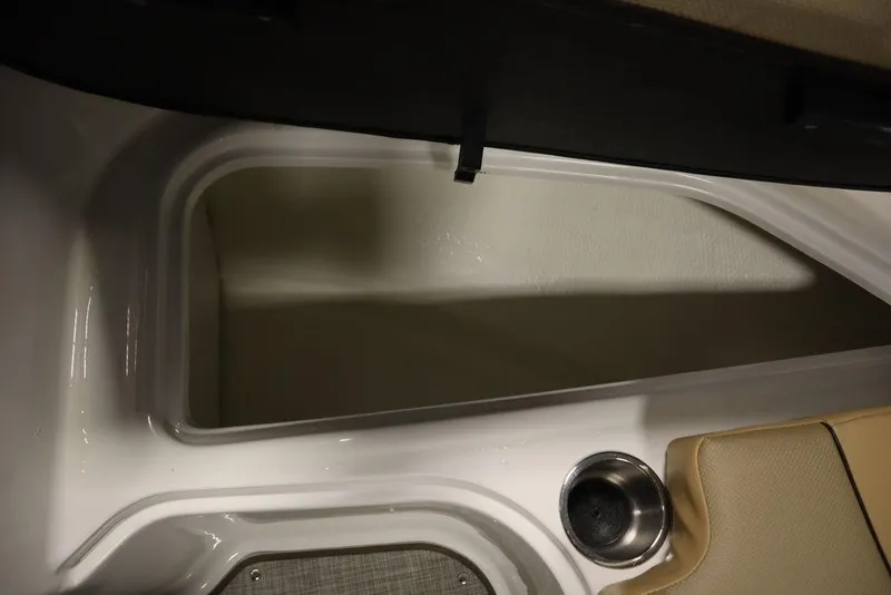 Slide: The Image of 2024 Bayliner VR5 Bowrider storage compartment with cup holder and beige seating. - 16