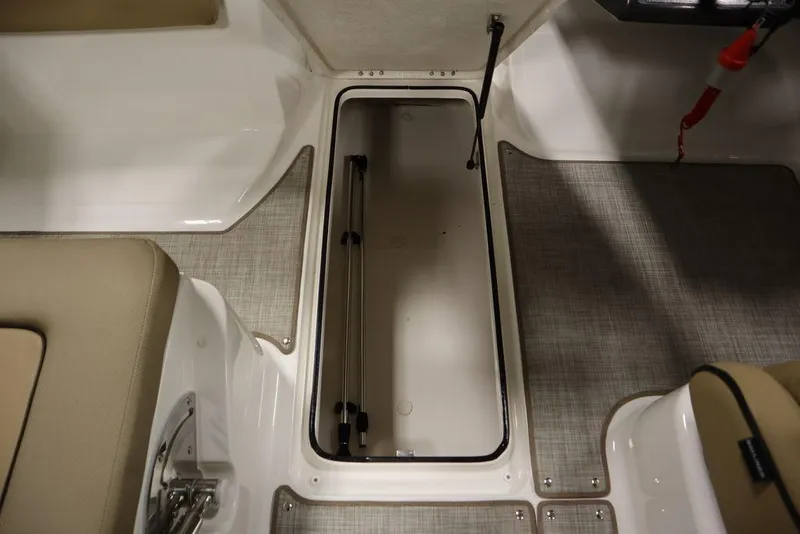 Slide: The Image of 2024 Bayliner VR5 Bowrider storage compartment with beige seating and gray flooring. - 26