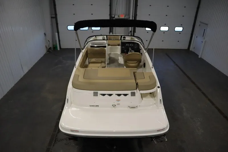 Slide: The Image of 2024 Bayliner VR5 Bowrider in a garage, featuring beige seating and a black canopy. - 5