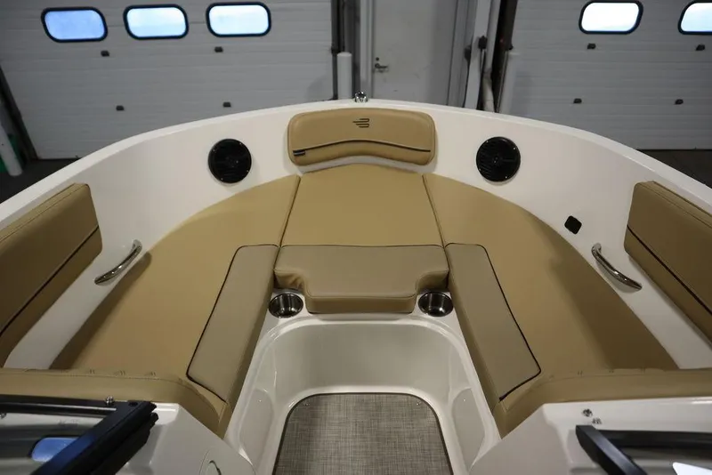 Slide: The Image of 2024 Bayliner VR5 Bowrider interior with tan seating and cup holders. - 8