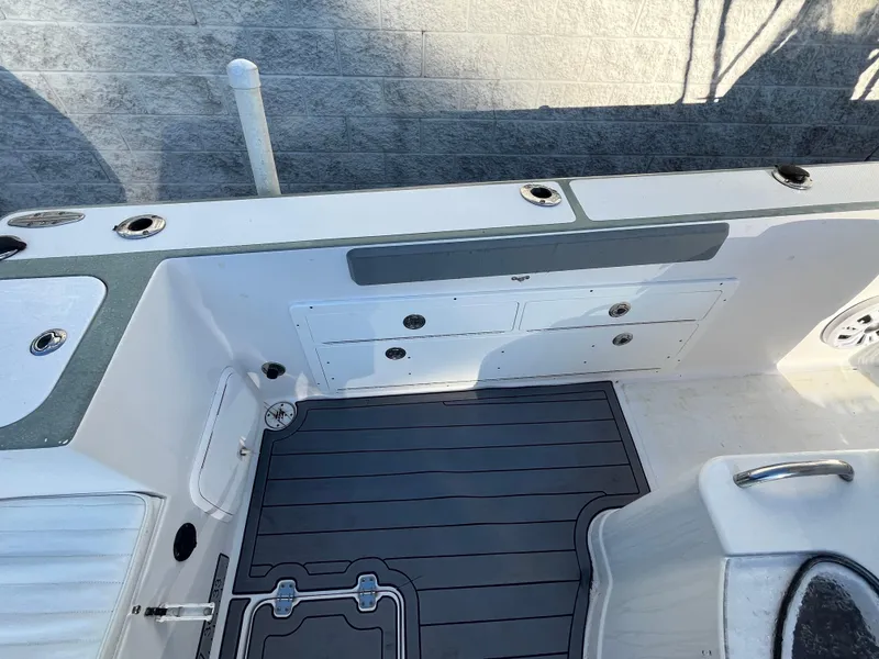Slide: The Image of 2003 Pro-Line 25 Sport CC boat interior with storage compartments and non-slip flooring. - 10