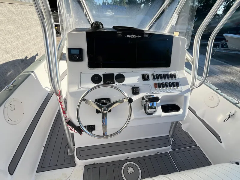 Slide: The Image of 2003 Pro-Line 25 Sport CC boat dashboard with steering wheel and control panel. - 14