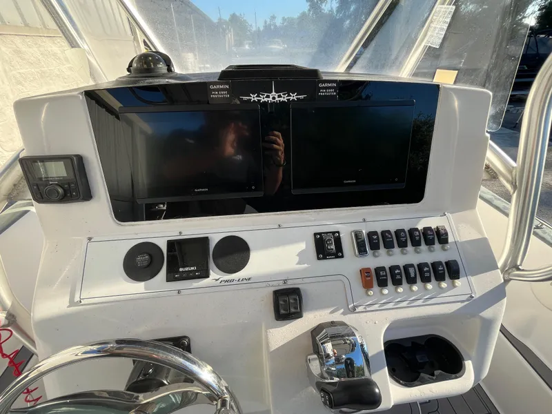 Slide: The Image of Control panel of a 2003 Pro-Line 25 Sport CC boat with Garmin displays and switches. - 15