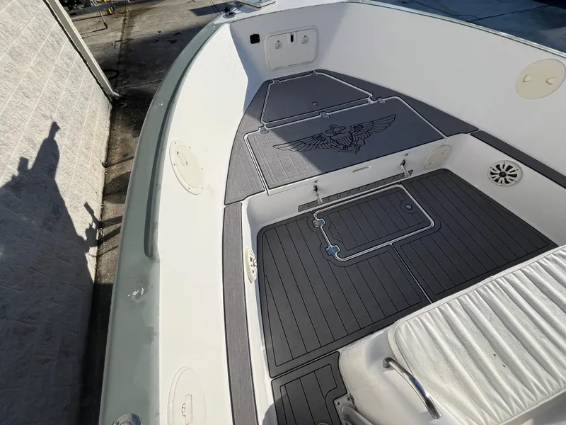 Slide: The Image of 2003 Pro-Line 25 Sport CC boat deck with custom flooring and nautical emblem. - 18