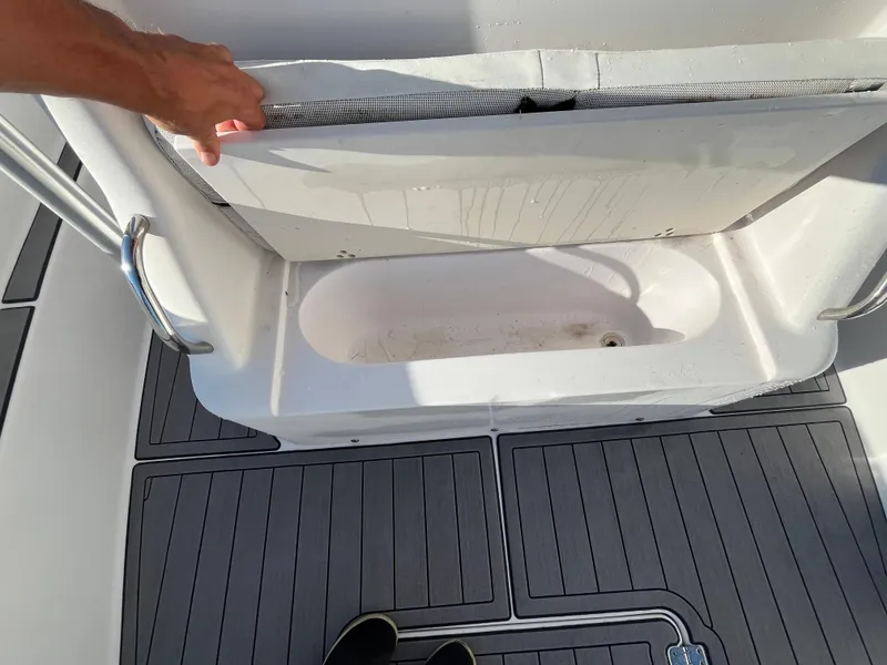 Slide: The Image of 2003 Pro-Line 25 Sport CC boat with open storage compartment on deck. - 20